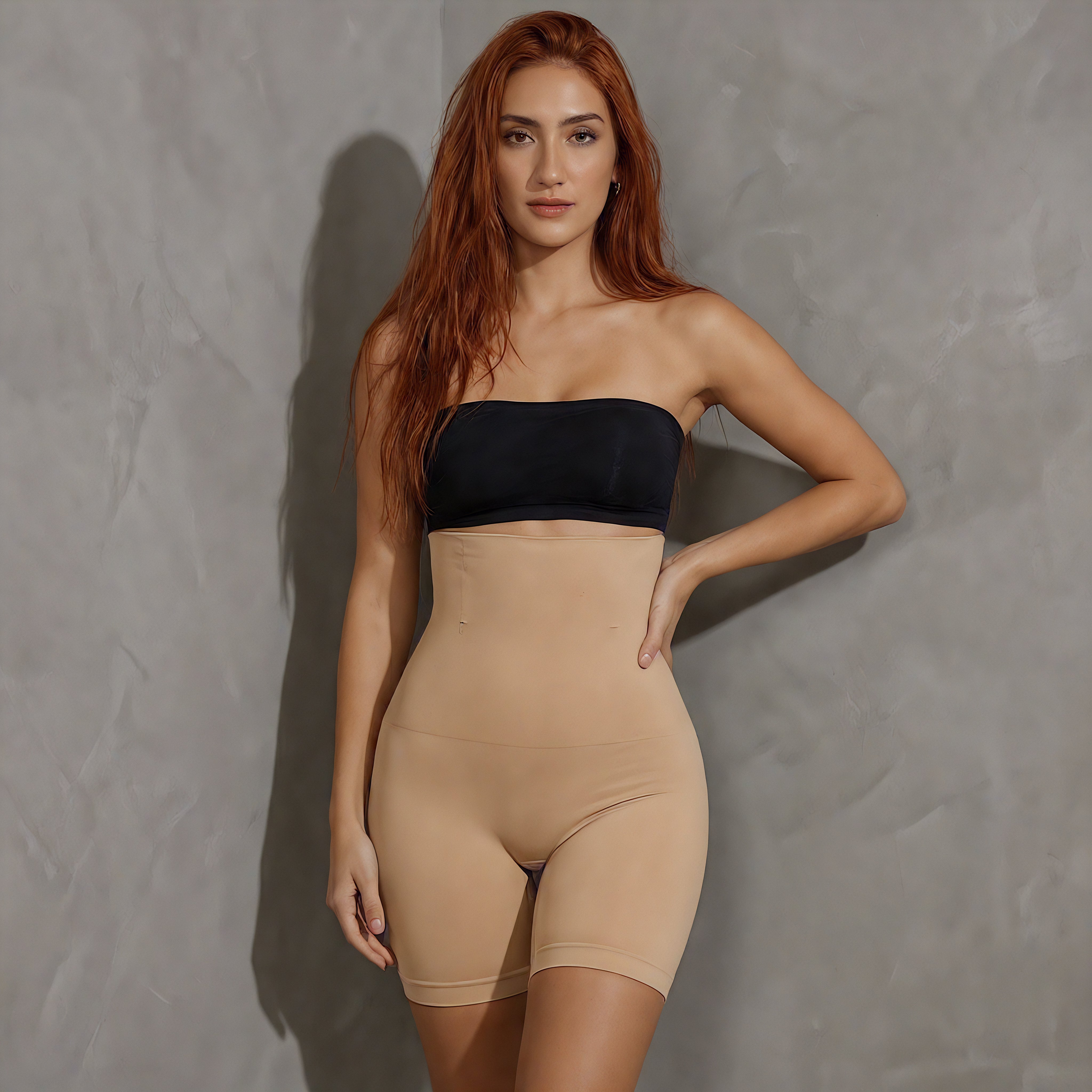 Woman wearing a black strapless top and beige shapewear against a gray background cream shapewear bottoms from lyvia