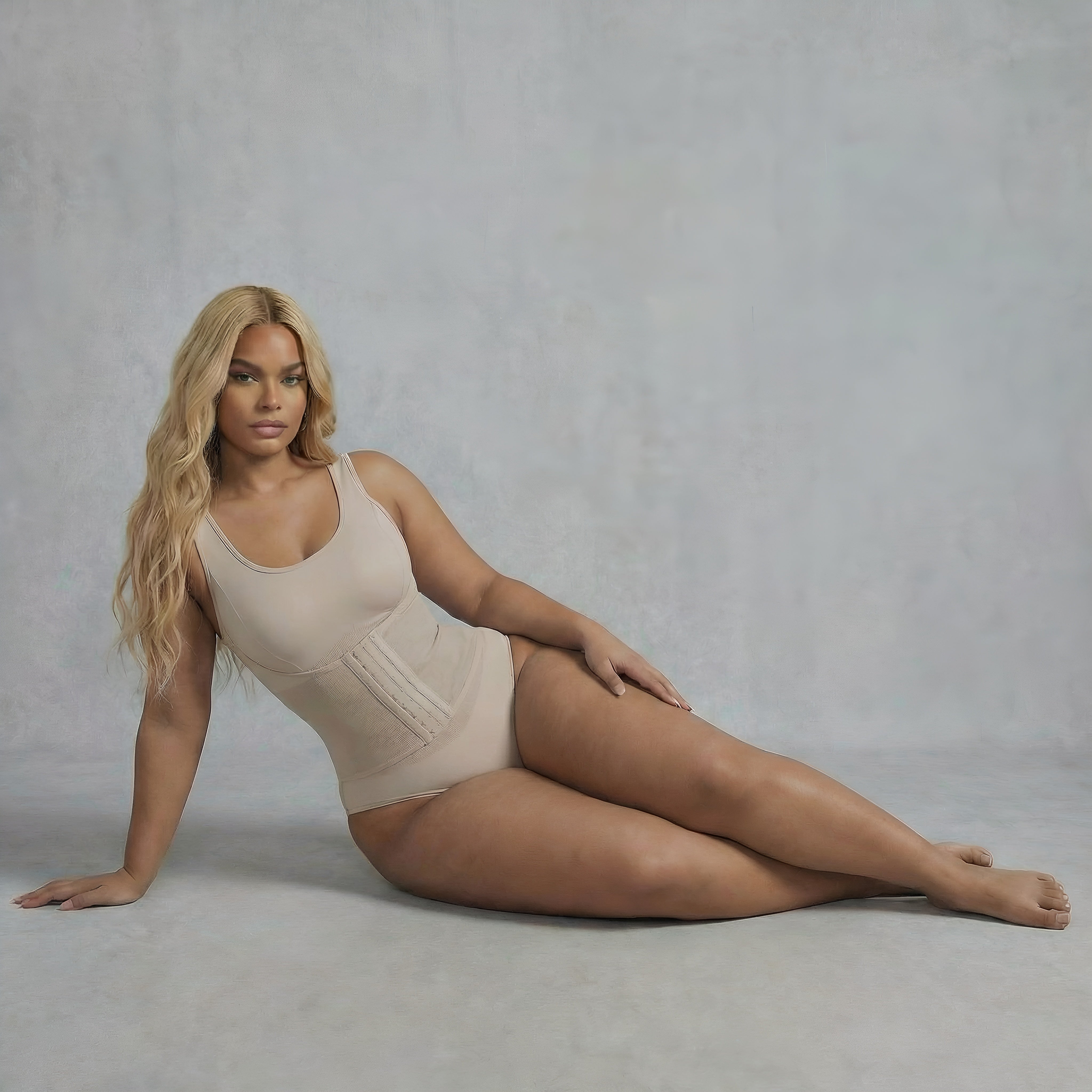 Woman wearing a beige bodysuit against a plain background. Woman wearing beige bodysuit shapewear lyvia.