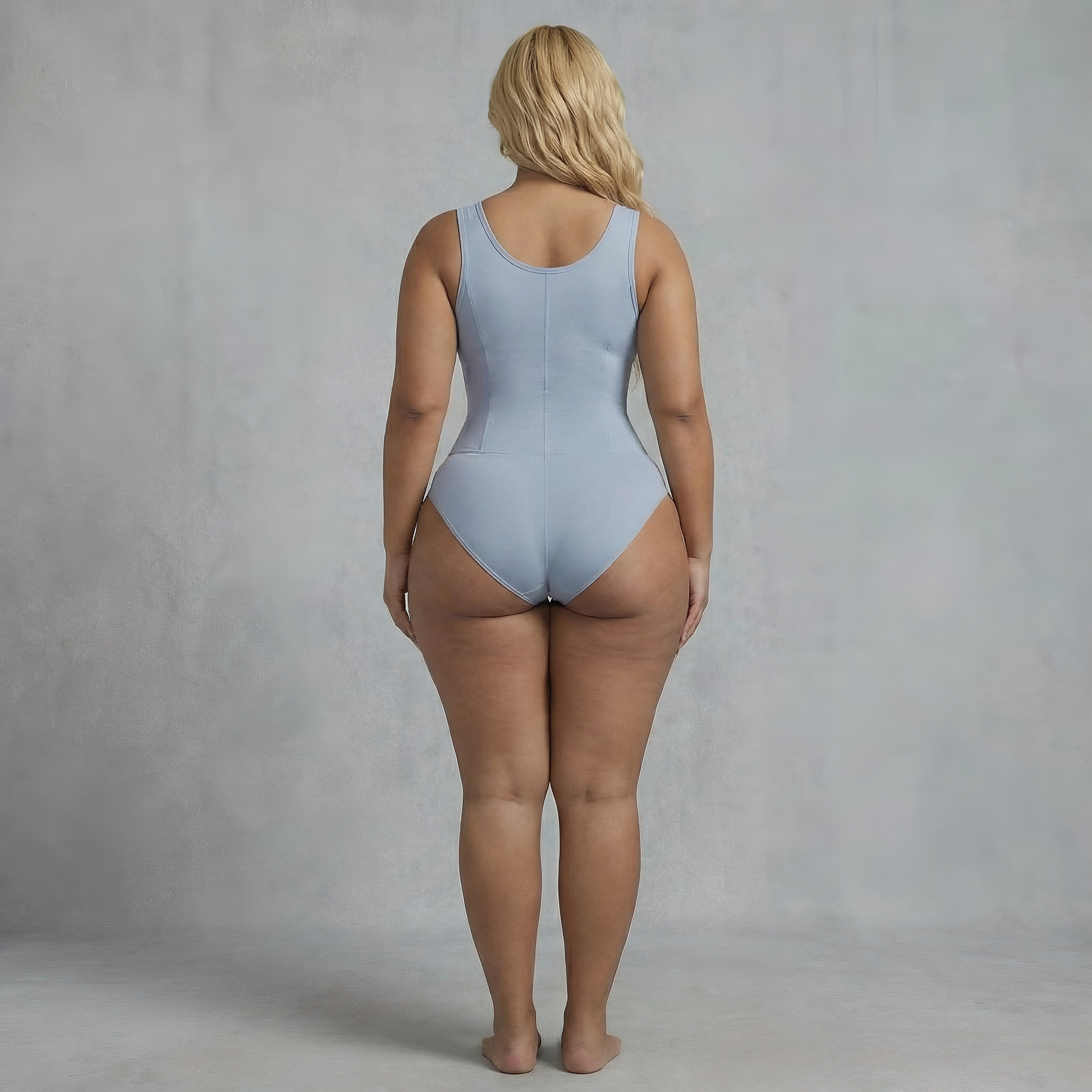 Person wearing a light blue swimsuit against a plain background. Curvy shapewear blue womans lyvia.